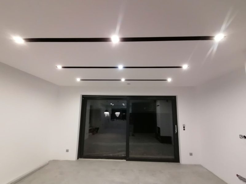 Detal sufitu podwieszanego z oświetleniem LED i wnękami pod tuby w salonie – Rudnik koło Stalowej Woli